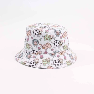 Close-up of white bucket hat featuring colorful cartoon cow and floral print patterns