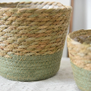 Detailed close-up of woven seagrass basket showing natural fiber texture and green stitching