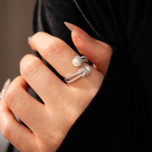 Detail of silver knot ring with two pearls and micro-pave cubic zirconia stones