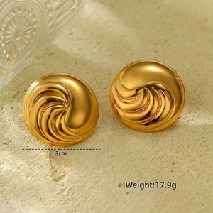Macro shot of gold spiral textured hoop earrings measuring 3cm in diameter and 17.9g weight