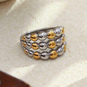 Detailed macro view of three-row beaded ring in alternating gold and silver finishes