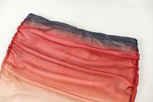 Detail of mesh fabric showing red and black gradient color and breathable texture