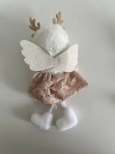 Detailed plush Christmas deer ornament with pink lace skirt and wings on white surface