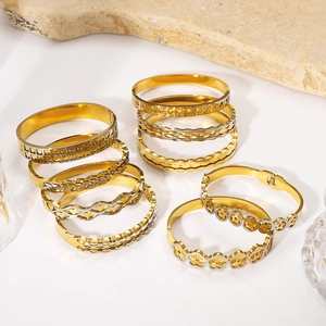 Gestapelte Armreifen aus 18k Gold und Edelstahl mit hohlen geometrischen Mustern