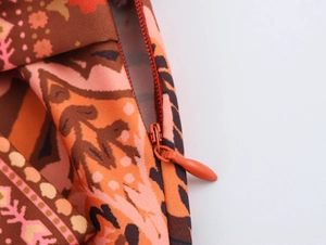 Detail of invisible zipper on orange ethnic printed skirt with boho floral pattern