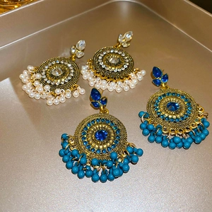 Ethnic vintage water drop fringe earrings with rhinestones and pearls on a golden tray