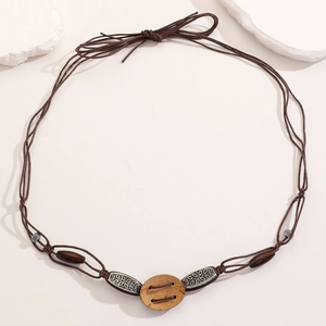 Detail of bohemian braided waist rope featuring vintage metal tubes and wooden beads