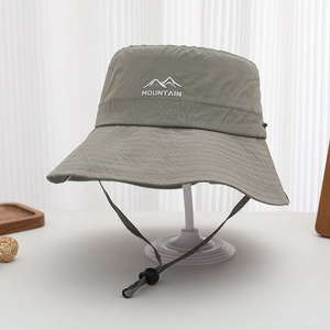 Detail of grey-green mountain logo print on nylon quick-dry bucket hat with wind rope