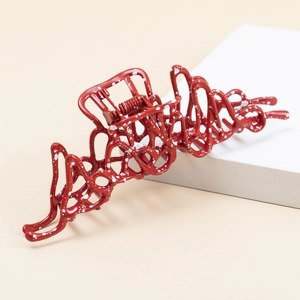 Detailed view of a red irregular liquid metal hair claw clip with white speckled dots
