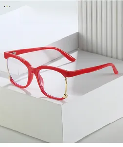 Detailed view of large square glasses in bright red with stylish gold metal accents