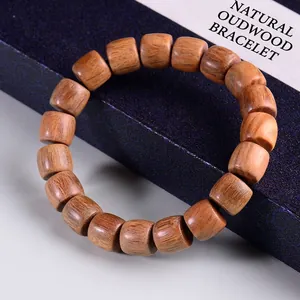 Ethnisches Sandelholz-Armband mit Tonnenperlen und Holzmaserung auf blauer Geschenkbox