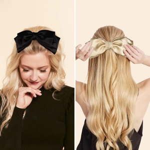 Detail view of large satin bow hair clips in black and champagne gold colors