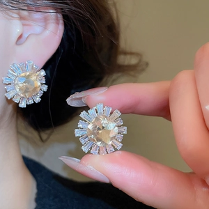 Macro shot of silver sunflower earrings with champagne zircon and baguette cut crystals