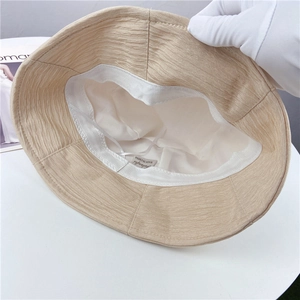 Détail intérieur d'un chapeau bob beige plissé avec doublure blanche et bande de confort