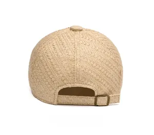 Detail view of woven straw baseball cap back with adjustable bronze buckle and strap