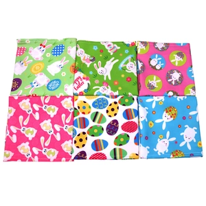 Detail view of Easter pet bandanas featuring colorful rabbit and egg print patterns