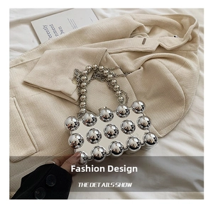 Detailed macro view of metallic silver beaded acrylic bag with sleek chain strap and polished finish