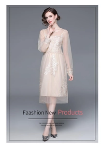 Détail de la broderie florale 3D blanche sur le tulle en maille abricot de cette robe midi