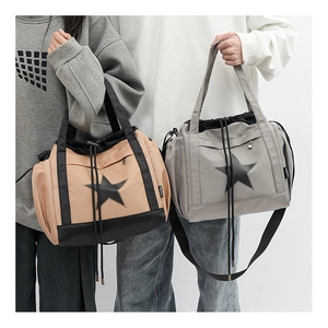 Detail of khaki and grey nylon tote bags featuring a black star logo and adjustable straps