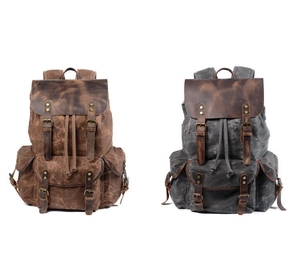 Detail of vintage canvas backpack showing leather straps and drawstring closure system