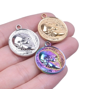 Macro view of skull coin pendants in gold, silver, and rainbow steel finishes for DIY jewelry