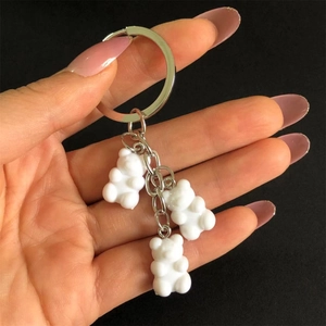 Detailed view of three white resin gummy bear charms on a silver metal keychain ring