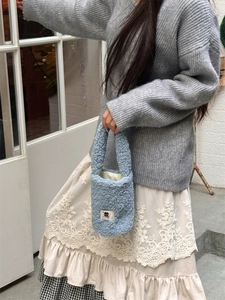 Detail of light blue sherpa fleece water bottle carrier with cute cartoon embroidery