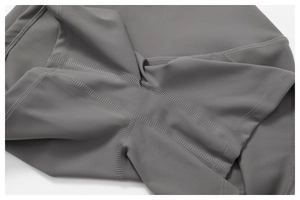 Detailed macro view of four-needle six-thread flatlock stitching on dark gray yoga wear