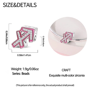Macro detail of pink enamel Sagittarius charm with silver base and white zirconia accents