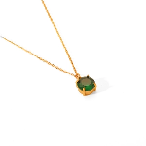 Detail of a minimalist gold necklace with a round green gemstone pendant on white background