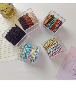 Close-up of high-elastic braided hair ties in various colors stored in clear boxes