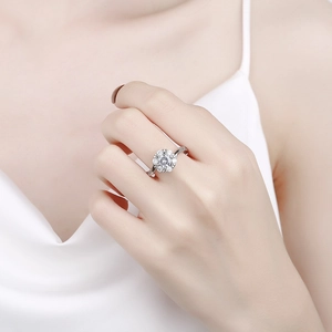Elegant silver flower-shaped moissanite ring with six-prong setting on a model's hand