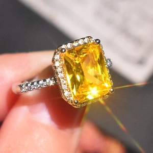 Close-up of luxury princess cut yellow diamond ring with micro-paved sparkling halo