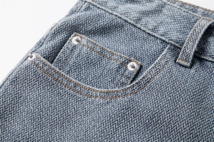 Macro detail of starry pattern denim shorts showing brown stitching and metal rivets
