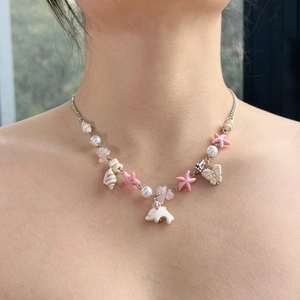Detailed close-up of a sweet dolphin shell necklace with beads and star charms
