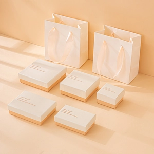 Set of beige and orange jewelry gift boxes and bags with elegant gold foil lettering