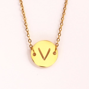 Détail du collier en acier inoxydable doré avec pendentif circulaire ajouré lettre V