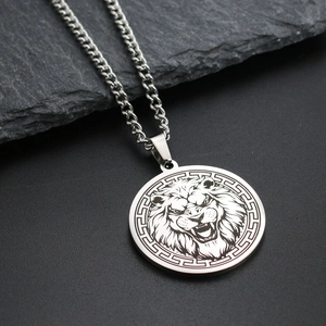 Detailed view of a silver lion head pendant on a metal chain over a textured stone surface