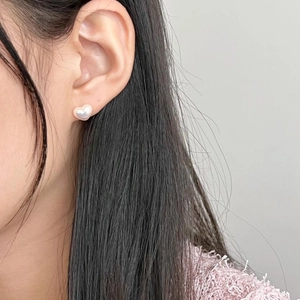 Elegant 925 sterling silver heart-shaped pearl stud earrings worn by a model