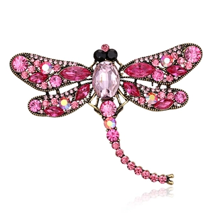 Detailed close-up of pink crystal dragonfly brooch with vintage gold finish metal wings