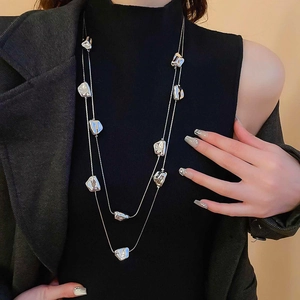Dettaglio della collana d'argento a due strati con ciondoli geometrici sulla modella