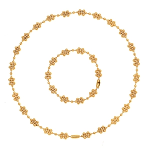 Golden minimalist jewelry set featuring beaded floral necklace and matching bracelet