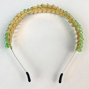 Handmade gold leaf headband with green crystal beads for women on white background