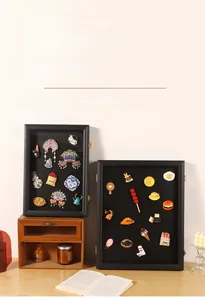 Detail of black magnetic shadow box with gold metal clasp showing pins and medals