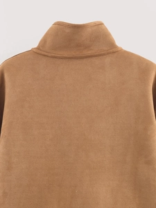 Detailed macro view of the premium brown suede texture on the back collar of the jacket