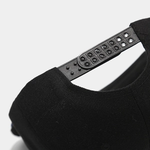 Detail of adjustable snapback closure on black hip-hop cap with visible fabric texture