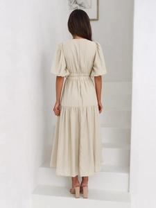 Detail of elegant beige puff sleeve dress with high waist and textured fabric from behind