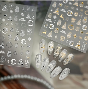 Details von Weihnachts-Nagelstickern mit goldenen Rentieren, Schneeflocken und Bäumen