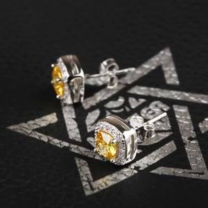 Macro shot of S925 sterling silver stamp on yellow zircon stud earrings with pavé halo