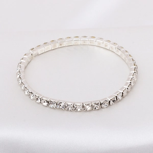 Close-up of silver-tone tennis bracelet with clear cubic zirconia on white silk
